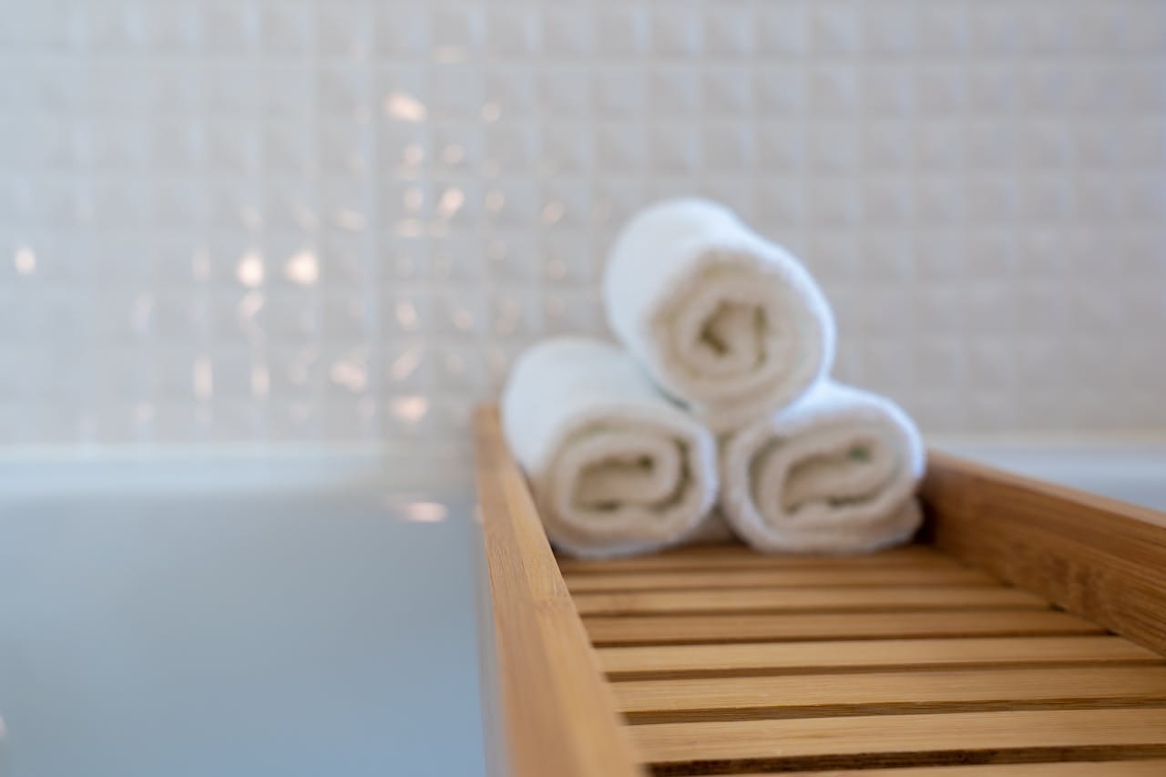Bath A stack of towels on a tray over a bath tub